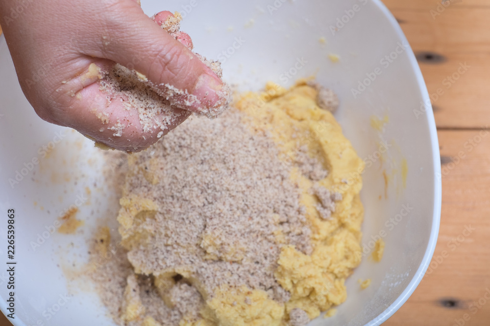 Close up of female hands making hazelnut cookies from sliced almonds and flour with coffee powder . Close up of female hands making hazelnut cookies from sliced almonds and flour with coffee powder .