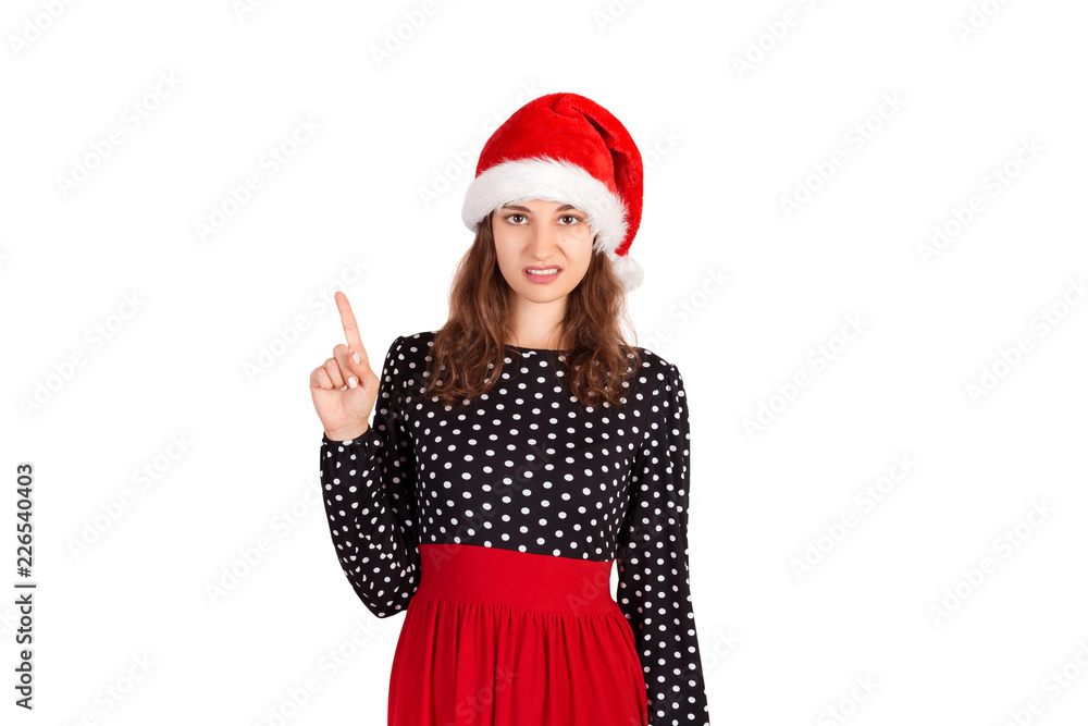 Portrait of attractive woman pointing up with index finger. emotional girl in santa claus christmas hat isolated on white background. holiday concept Portrait of attractive woman pointing up with index finger. emotional girl in santa claus christmas hat isolated on white background. holiday concept