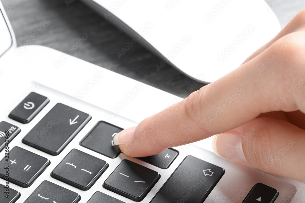 Woman pressing button on laptop keyboard, closeup Woman pressing button on laptop keyboard, closeup