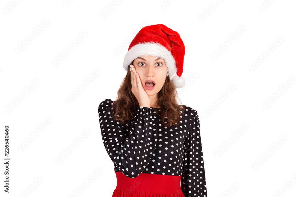 Portrait of amazed and surprised cute female dropping jaw and gasping with opened mouth left being impressed and shocked. emotional girl in santa claus christmas hat isolated on white background Portrait of amazed and surprised cute female dropping jaw and gasping with opened mouth left being impressed and shocked. emotional girl in santa claus christmas hat isolated on white background