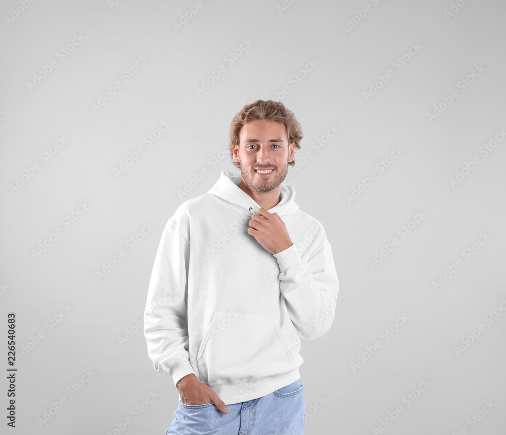 Portrait of man in hoodie sweater on light background. Space for design Portrait of man in hoodie sweater on light background. Space for design