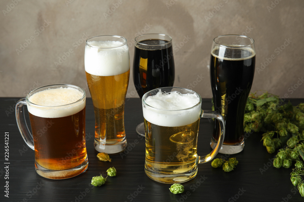 Composition with tasty beers and fresh green hops on table Composition with tasty beers and fresh green hops on table