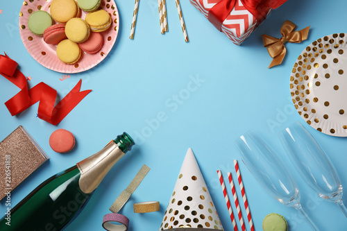 Creative flat lay composition with bottle of champagne and party accessories on color background. Space for text
