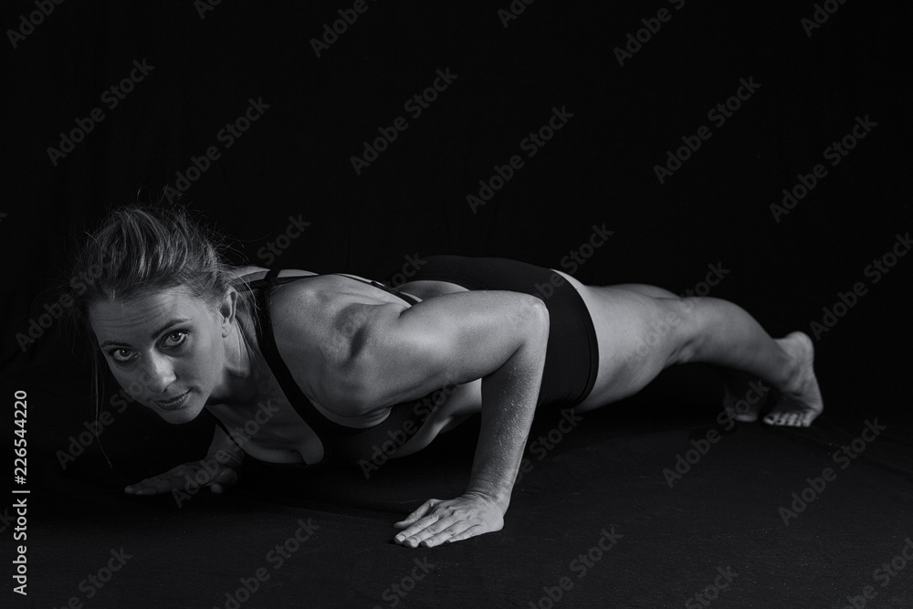 Fit woman with shaped muscles in push-up position artistic conversion