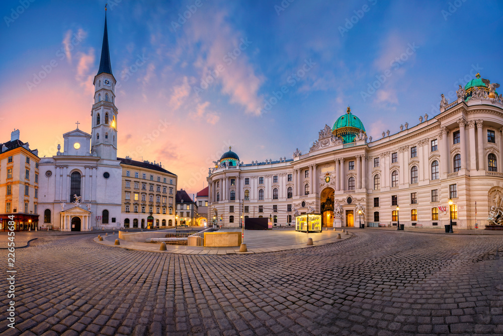 Naklejka premium Wiedeń, Austria. Pejzaż miejski Wiednia z kościołem św. Michała i znajdujący się na placu św. Michała podczas wschodu słońca.