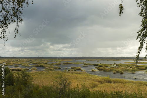 View from bird watching tower in Kanieris, Latvia. Sunset pink skies, river with deep blue reflection and trees. photo