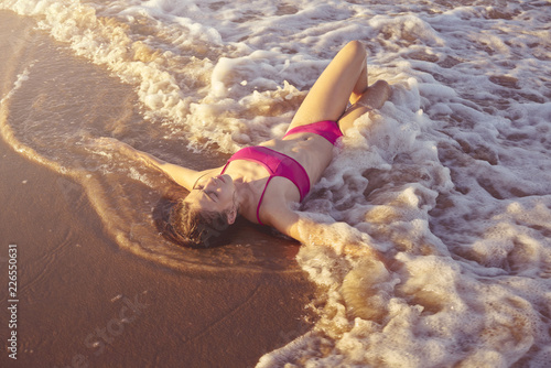 Bikini girl relaxed lying on the beach sand