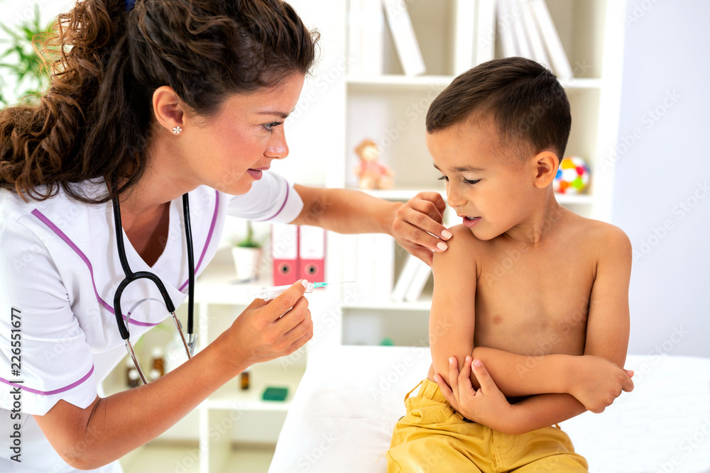 Pediatrician giving child a vaccine Pediatrician giving child a vaccine