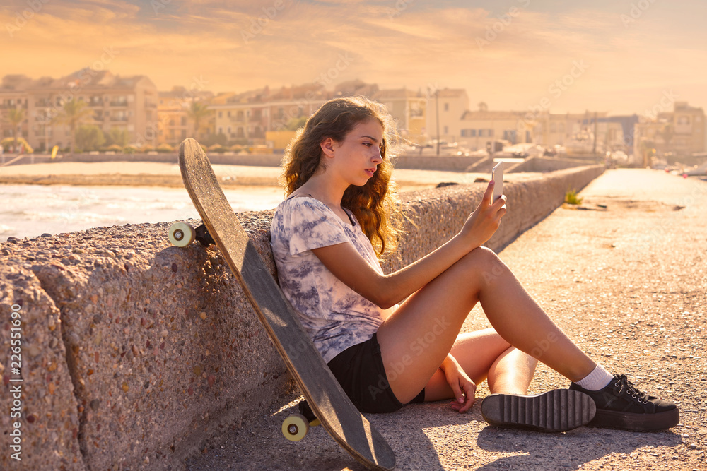 Roller Skate girl with smartphone sitting Roller Skate girl with smartphone sitting