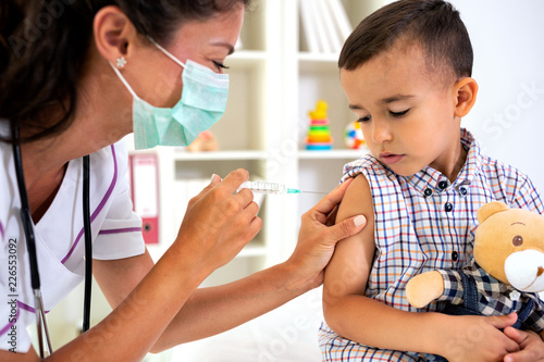 Little brave man receiving a vaccine photo