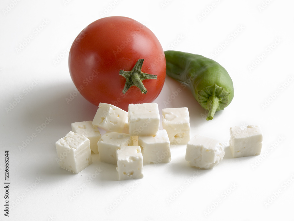 Bodegón de un tomate, un pimiento verde y taquitos de queso fresco