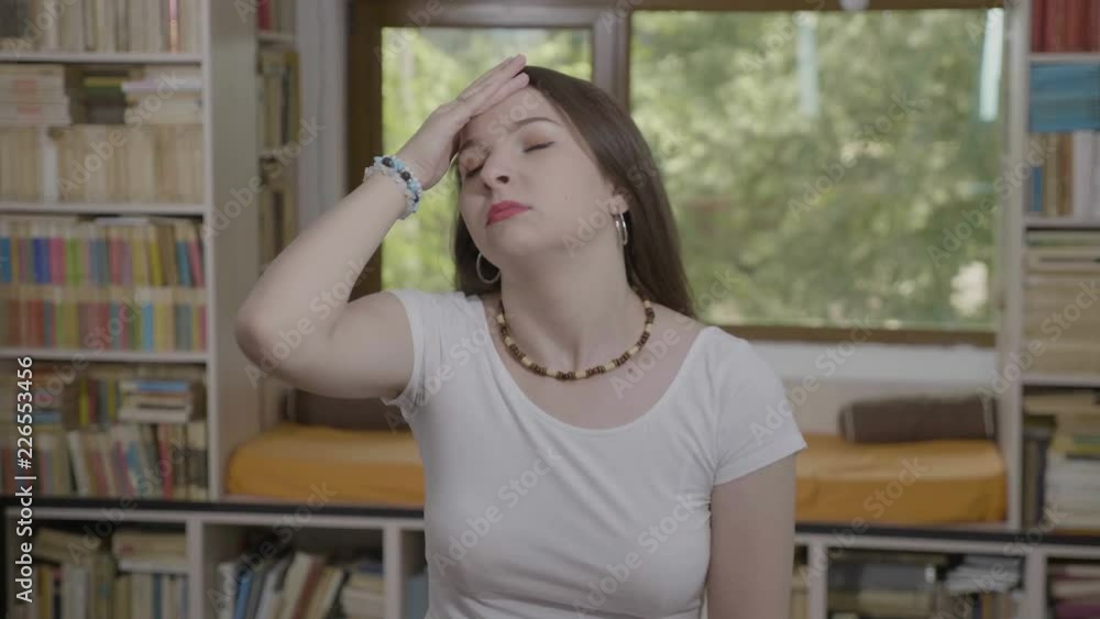 Teenage woman slapping her face gesturing facepalm expressing exasperation and annoyance Teenage woman slapping her face gesturing facepalm expressing exasperation and annoyance
