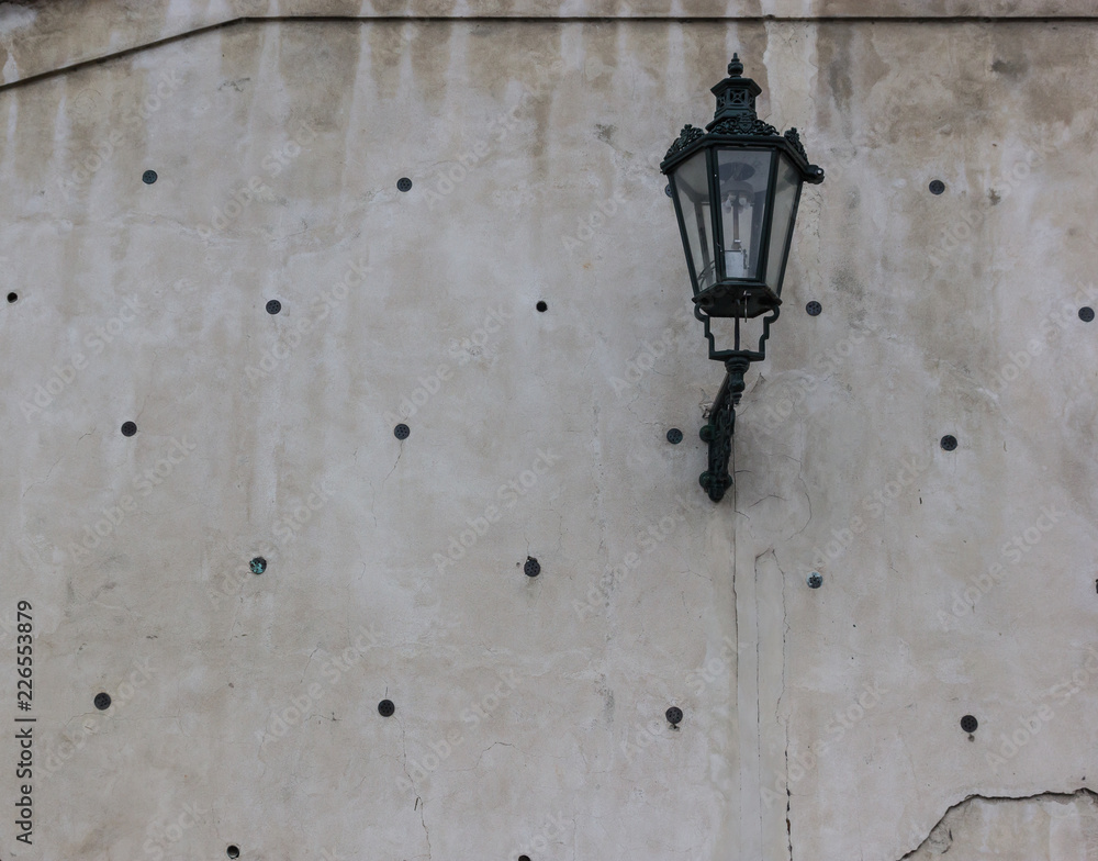 Old grey wall with holes, cracks with big retro lamp