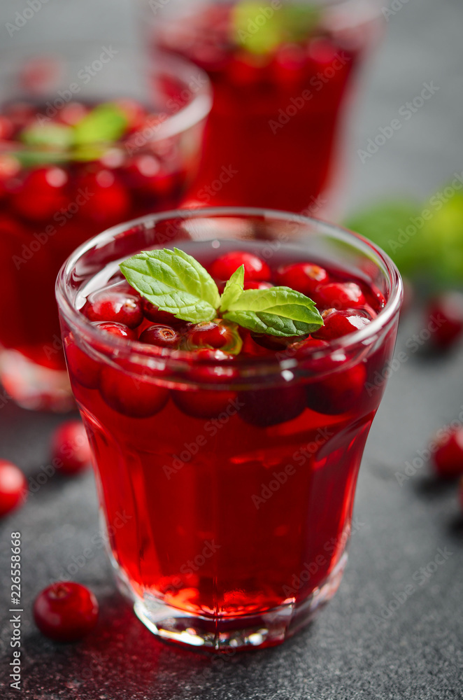 Refreshing cocktail with cranberry and mint on dark concrete background Refreshing cocktail with cranberry and mint on dark concrete background
