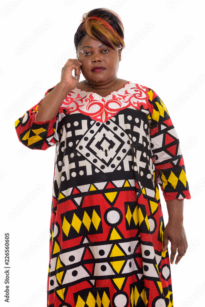 Studio shot of fat black African woman standing while talking on Studio shot of fat black African woman standing while talking on