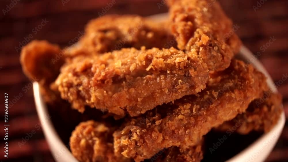 Rotation Bucket full of crispy fried chicken with smoke on brown background. Rotation Bucket full of crispy fried chicken with smoke on brown background.