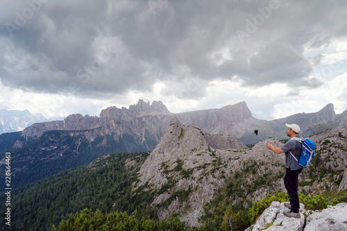 Man takes pictures with his cell phone to the mountain landscape of the Alpine peaks.