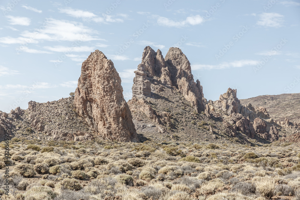 Group of large lava rocks in the middle of a desert landscape, on a sunny day