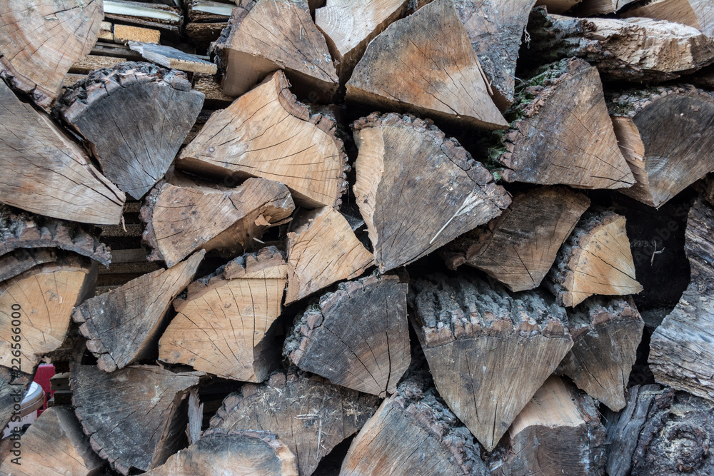Firewood in woodpile, prepared for Winter. Pile of firewood. The firewood background. A stack of neatly stacked, dry firewood outdoors. Firewood in woodpile, prepared for Winter. Pile of firewood. The firewood background. A stack of neatly stacked, dry firewood outdoors.