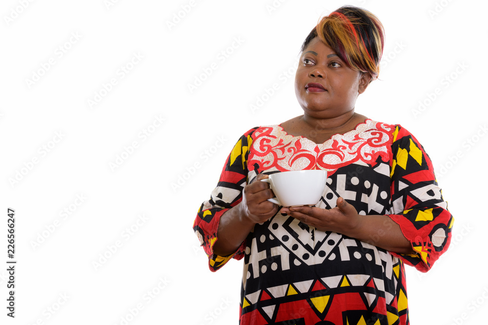 Studio shot of fat black African woman holding coffee cup while Studio shot of fat black African woman holding coffee cup while