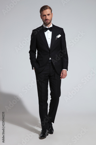 young elegant groom stepping forward with hand in pocket photo