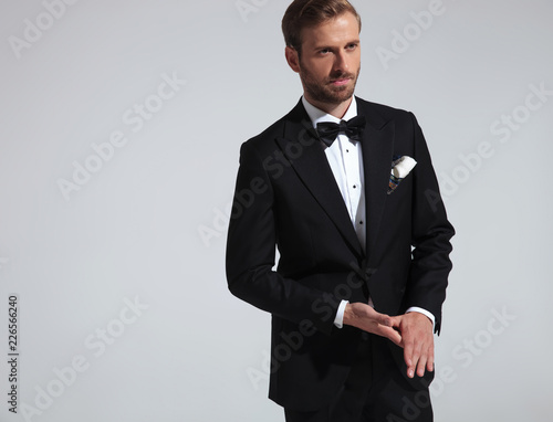 young elegant man in tuxedo holding palms together