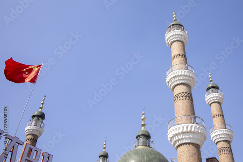 Chinese flag next to minarets of mosque, Urumchi, Xinjiang, China