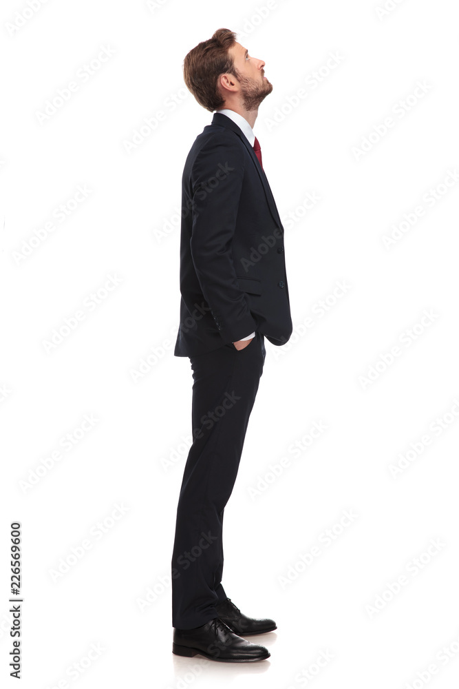 young businessman waiting in line looks up at something young businessman waiting in line looks up at something