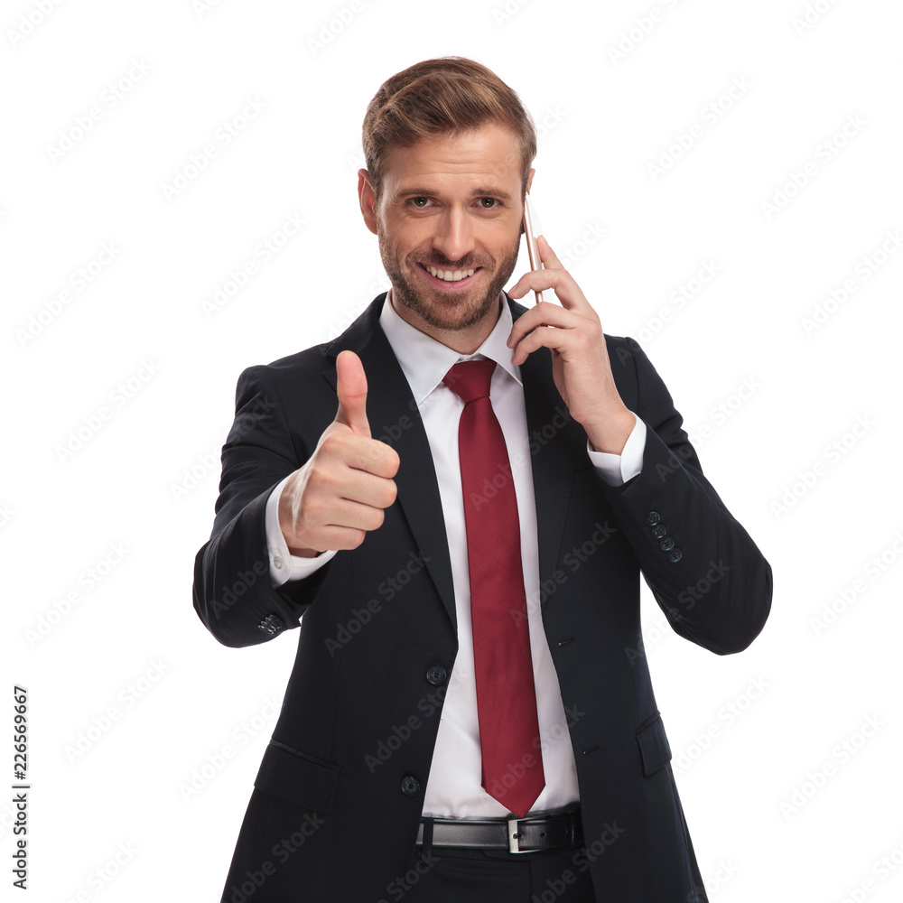 portrait of businessman talking on phone and making ok sign portrait of businessman talking on phone and making ok sign