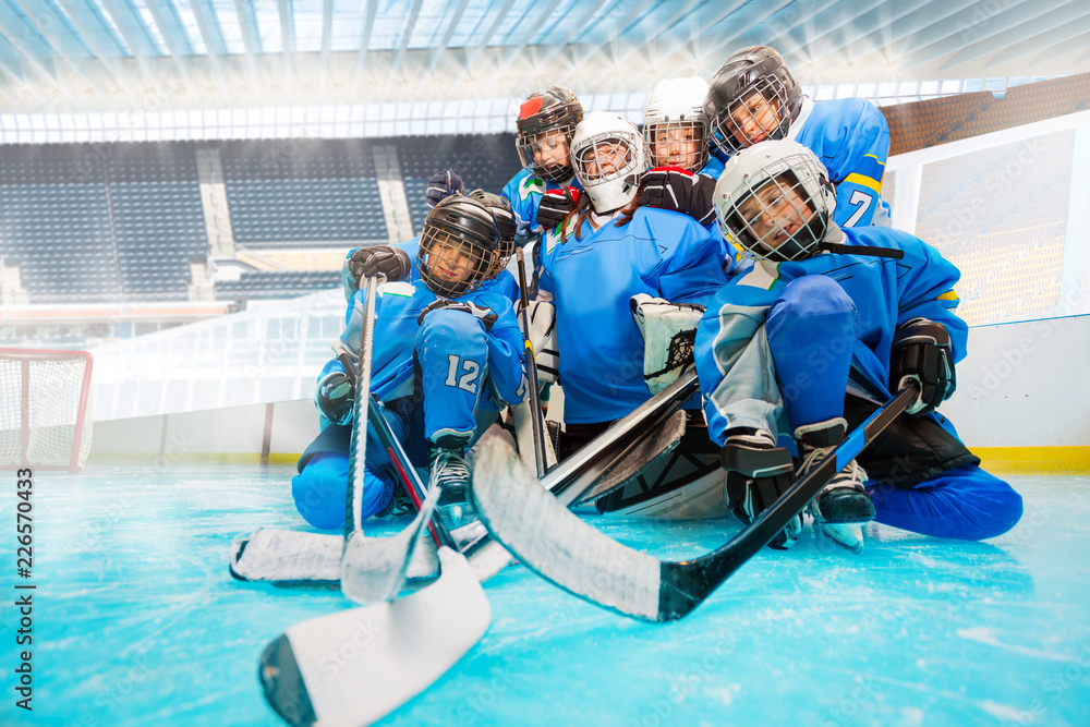 Fototapeta premium Junior hockey team with goalie on ice rink