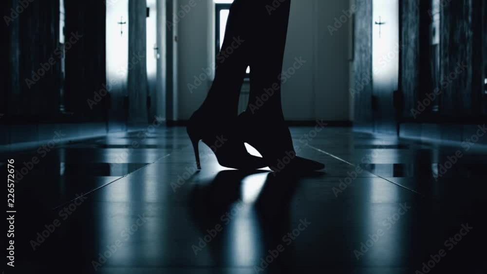 Close-up of a silhouette of women's shoes with high thin heels of a woman’s heels during a walk down the corridor. Business lady incognito. Intrigue in the business game. A dark horse. Close-up of a silhouette of women's shoes with high thin heels of a woman’s heels during a walk down the corridor. Business lady incognito. Intrigue in the business game. A dark horse.