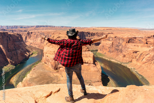 Man in cowboy hat and checkerboard shirt overlooking horshoe bend