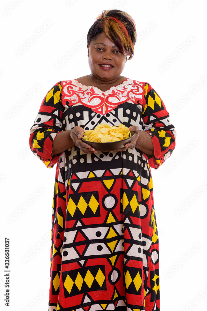Studio shot of happy fat black African woman smiling and standin