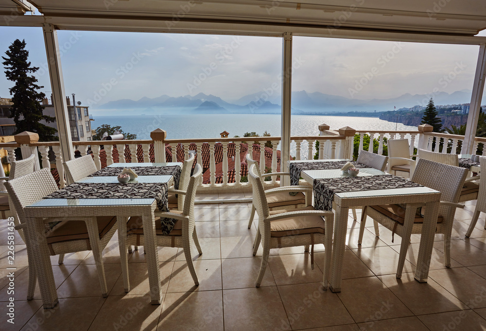 Restaurant at edge of cliff near blue sea in Konyaalti district of popular resort city Antalya, Turkey.