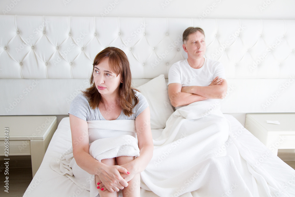 Family life concept.Problems in relationships. Middle age couple in bedroom. Man and woman in bed. Quarrel and upset emotions. Selective focus Family life concept.Problems in relationships. Middle age couple in bedroom. Man and woman in bed. Quarrel and upset emotions. Selective focus