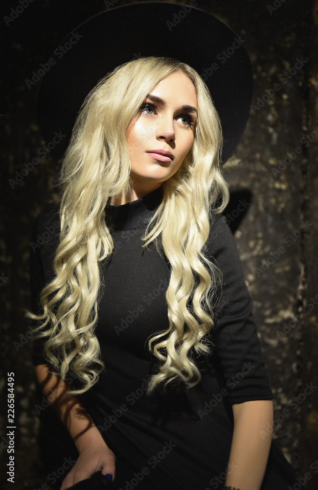 portrait of a girl in a hat with white long wavy hair on a dark brown and black background portrait of a girl in a hat with white long wavy hair on a dark brown and black background