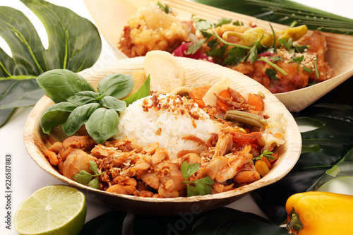 various street food with chicken wings on rustic background. balinese nasi campur and indian and brasilian street food. photo