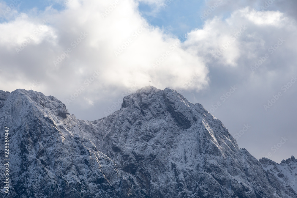 People on Giewont Mountain in polish Tatra Mountains covered with snow in autumn.