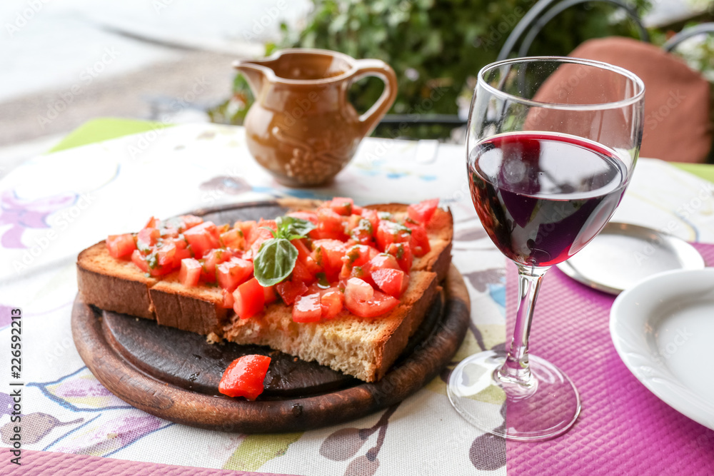 bruschetta in a heart form with home made wine on a restaurant table bruschetta in a heart form with home made wine on a restaurant table