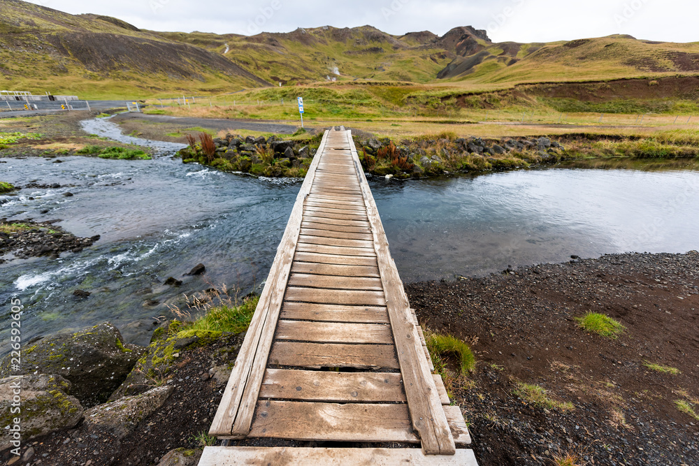 Hveragerdi Hot Springs trail in Reykjadalur, during autumn summer morning day in south Iceland, golden circle, rocks and wooden bridge crossing river steam