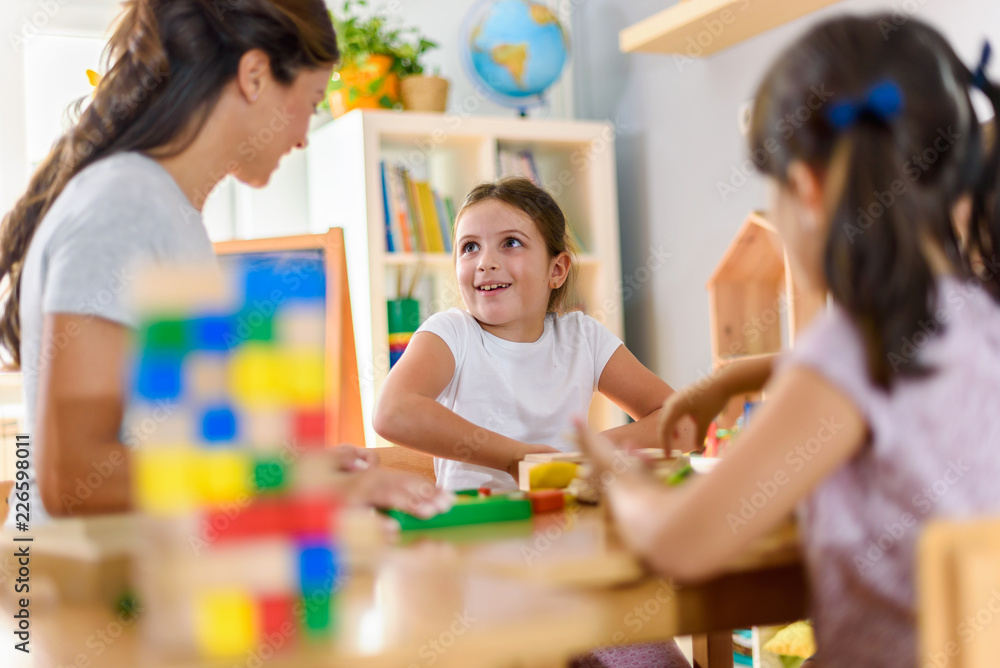 Preschool Teacher With Children Playing With Colorful Wooden Didactic