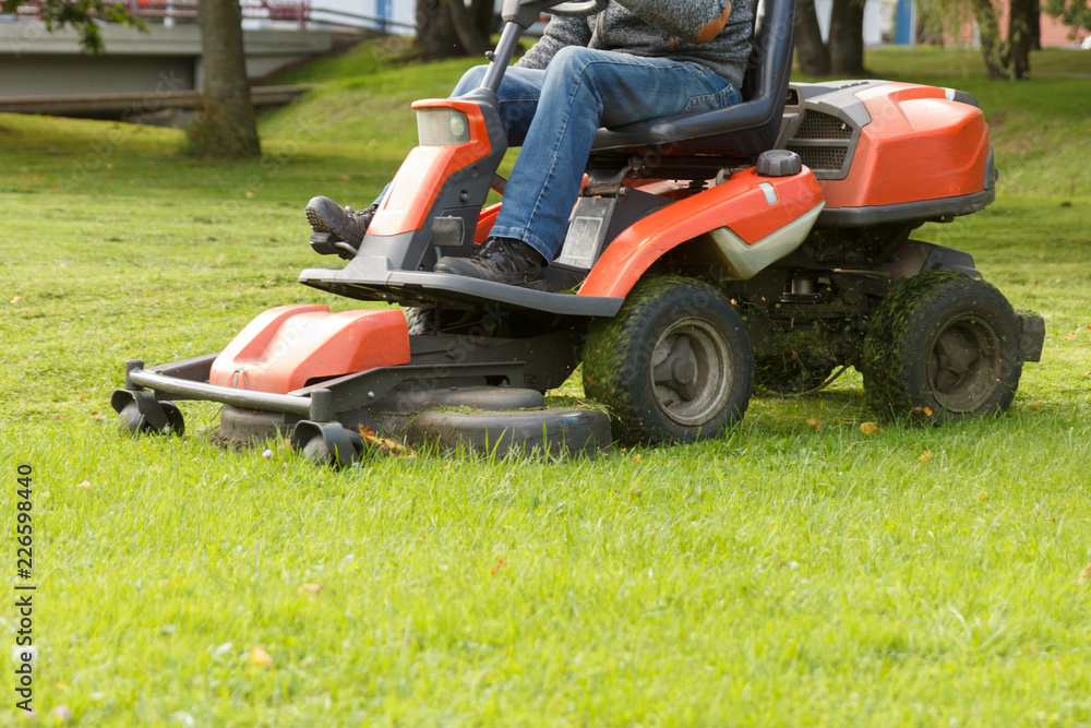 lawn mower tractor working in the town park lawn mower tractor working in the town park