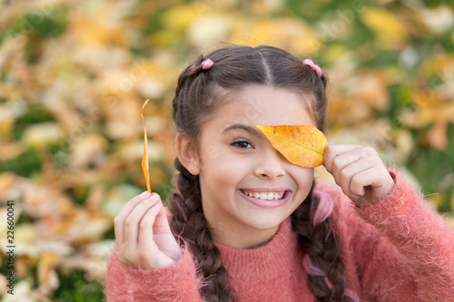 Happy childhood. School time. Small child with autumn leaves. Happy little girl in autumn forest. Autumn leaves and nature. Feeling free and relaxed. Happy to be around. Trendy beauty