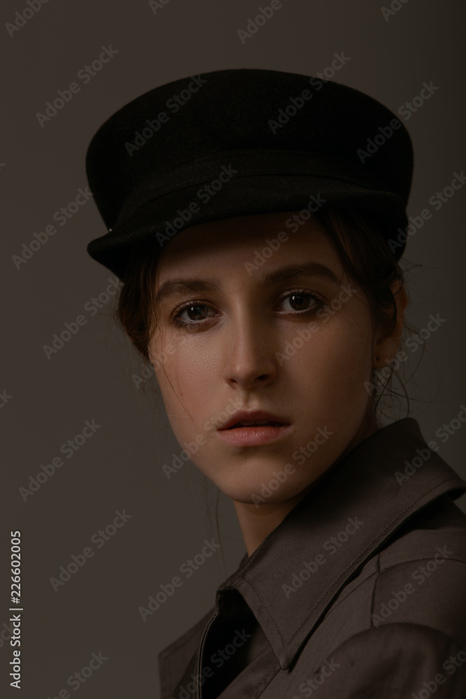 Art portrait of a beautiful girl in stylish clothes in the studio