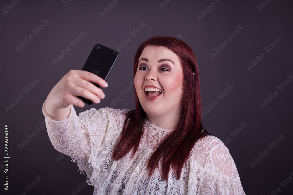 Young plus size woman taking selfie smiling with mobile phone Young plus size woman taking selfie smiling with mobile phone