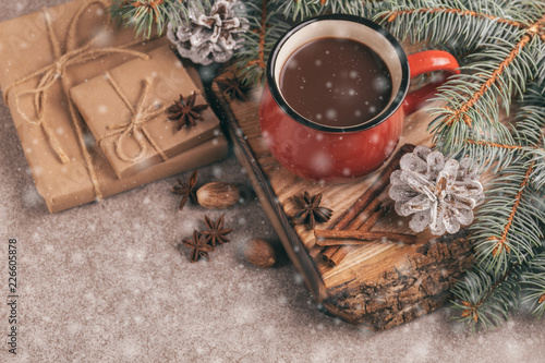 Red cup of hot cocoa on wooden cutting board photo