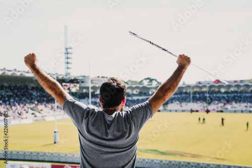 Φωτογραφία .Young man enjoying a rugby match at the stadium on a sunny autumn day. Screamin