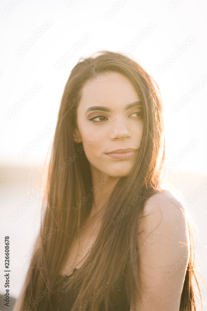 Portrait of a young woman standing on a pier during the golden hour. Portrait of a young woman standing on a pier during the golden hour.