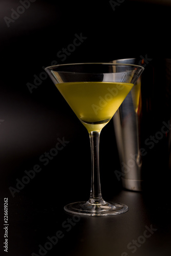 yellow cocktail with shaker on black background