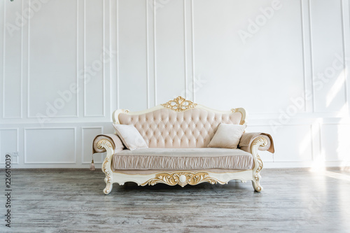 beautiful expensive beige sofa against a white wall in an empty room